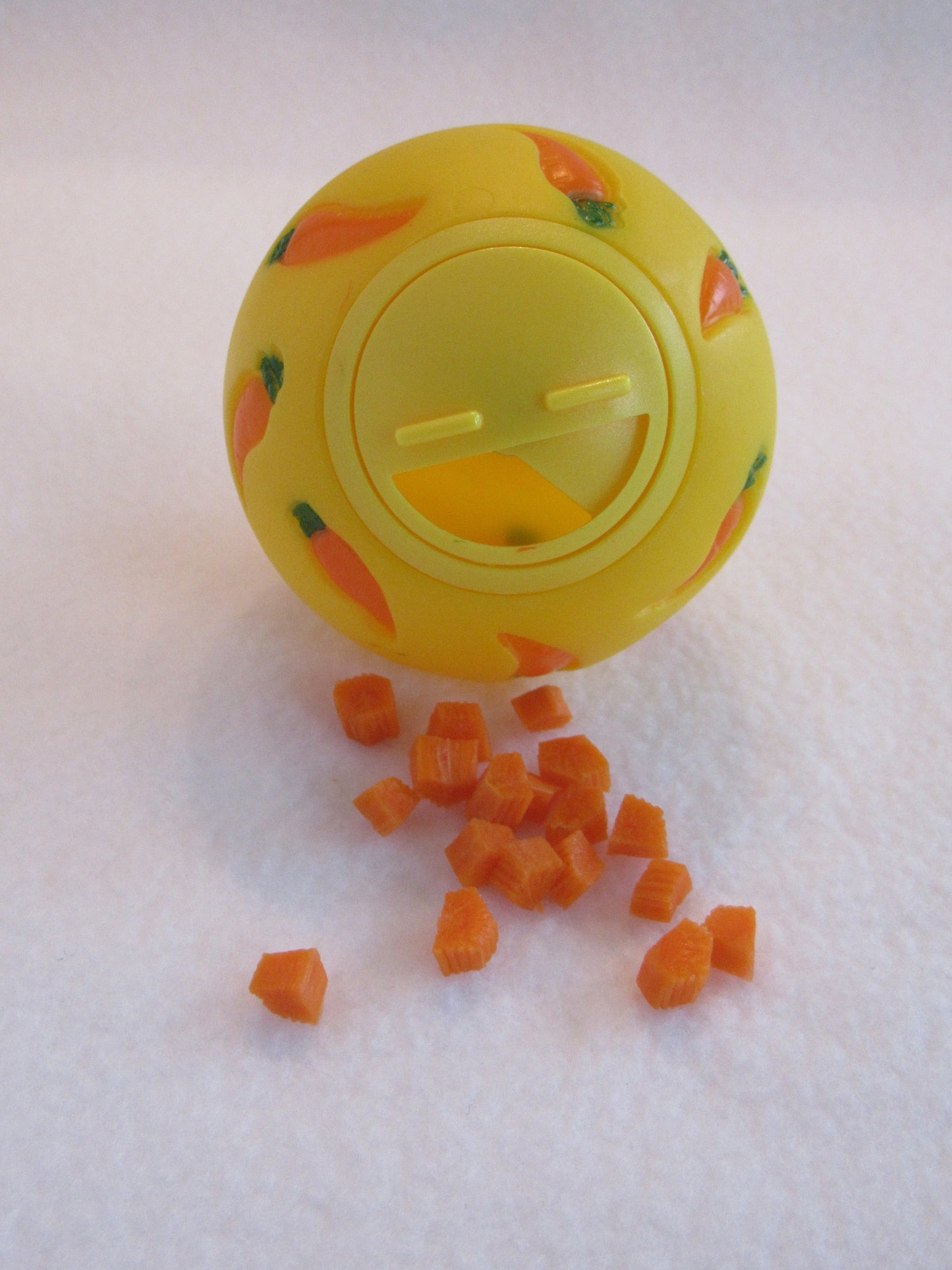 A WheekyⓇ Treat Ball filled with carrots for Guinea Pigs, Rabbits, Hedgehogs and Small Pets.